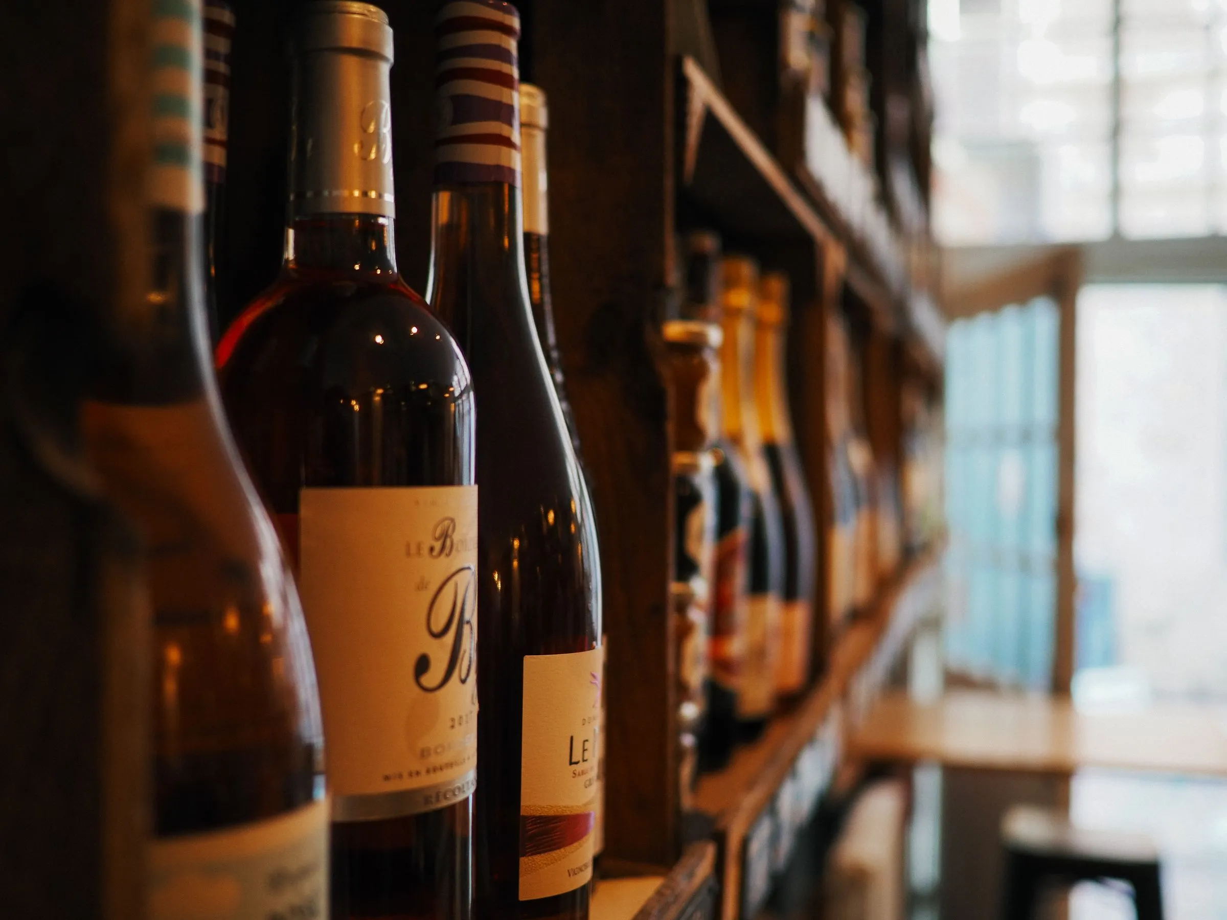 A curated collection of wine bottles on wooden shelves